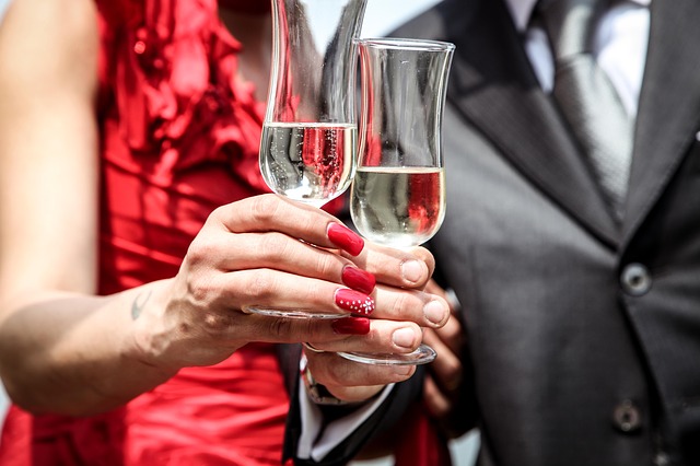 A couple in a formal dress holding a glass of wine